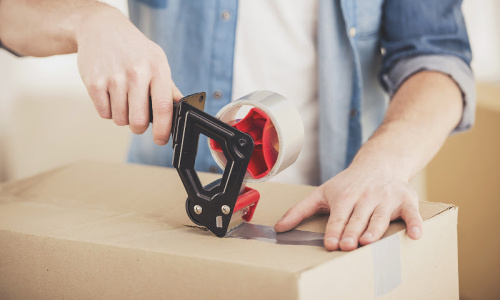 a man tapes up a moving box