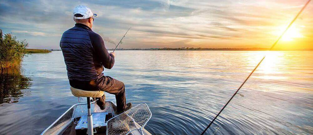  A Man fishes from his boat at sunrise