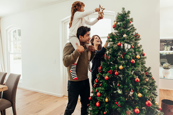 A family prepares their Christmas tree for the holidays.