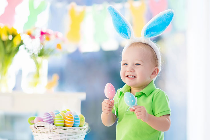 Little boy holds Easter decorations leading up to the Easter holiday.