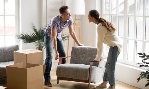 Couple moving chair to storage unit