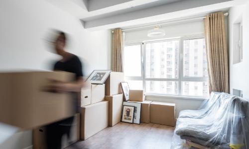 Man moving boxes from room
