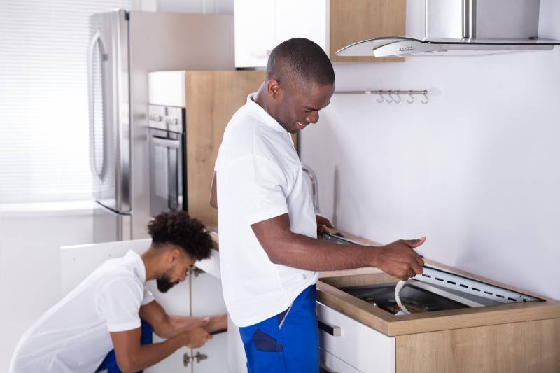 Two men prepare a stove and oven for a move to self storage