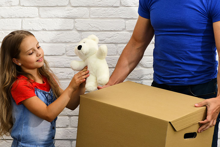 Little girl prepares an old toy for storage