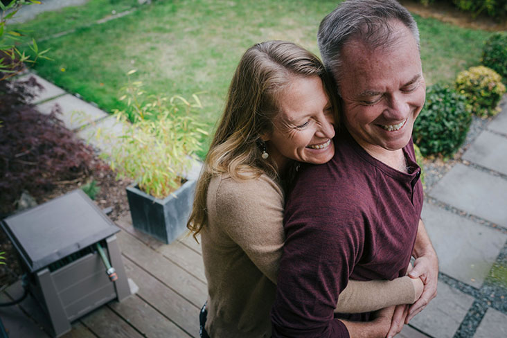 Smiling couple hug outdoors