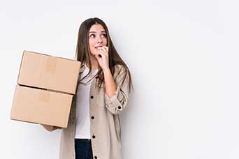 Woman holding boxes with a puzzled expression