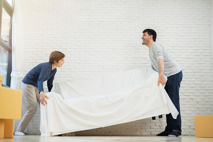 Man and boy move couch into self storage unit