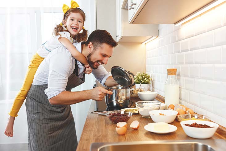 Family cooks with kitchen items prior to moving utensils into storage