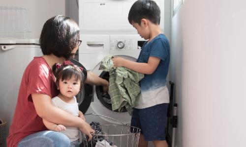 Family helping with laundry at the washing machine